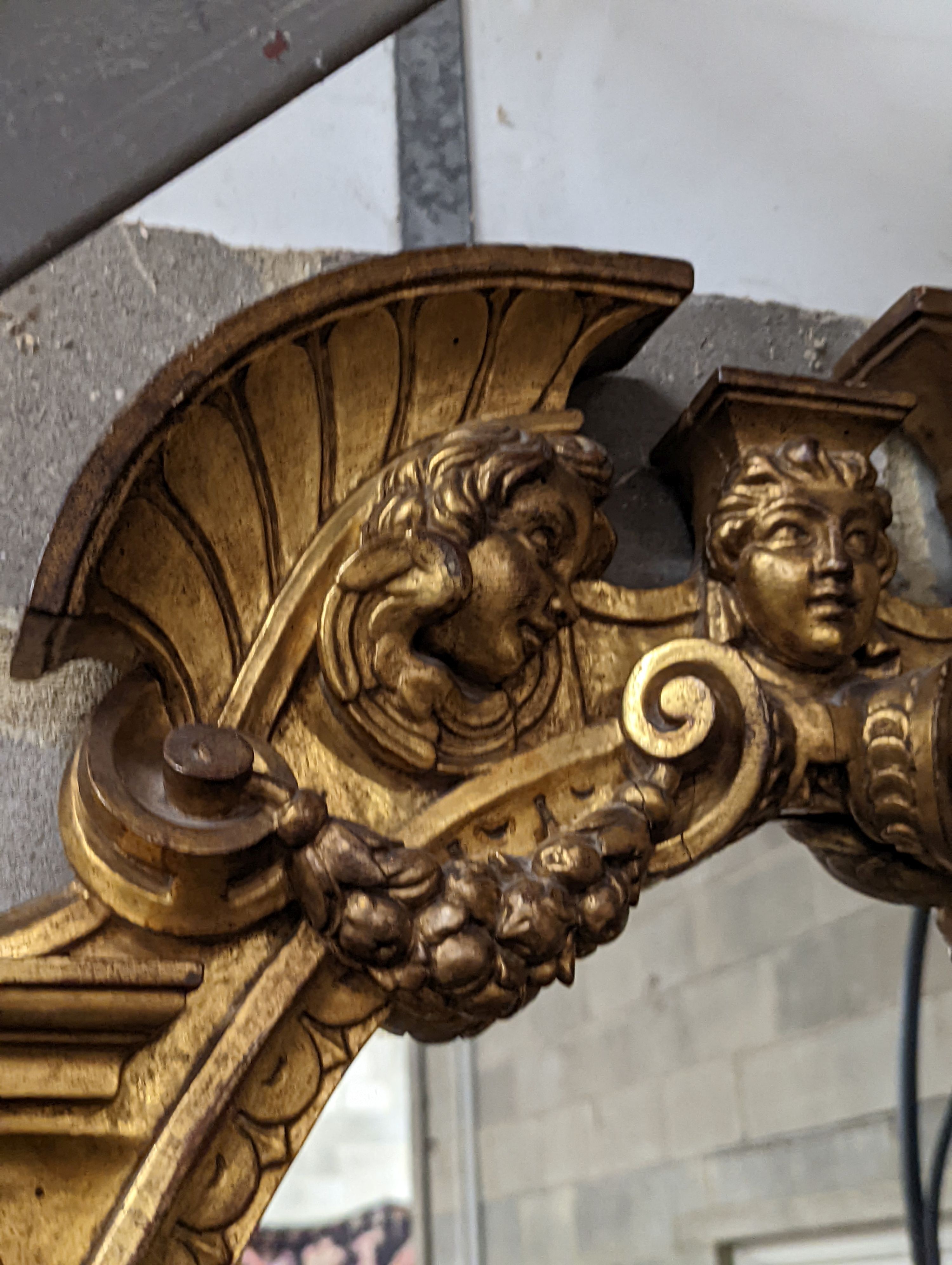 A Victorian carved giltwood oval wall mirror decorated with cherubs and C scrolls., width 74cm, height 110cm